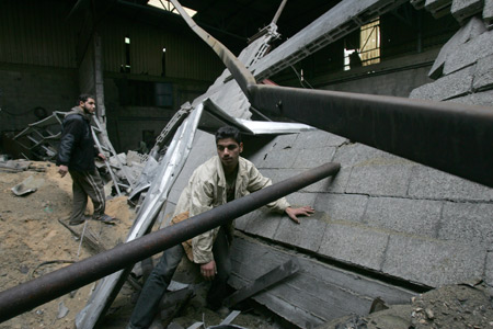 Palestinians check the site damaged by Israeli air strike in Gaza City, November 24, 2009. The Israeli army said it carried out three air strikes in the Gaza Strip, targeting the facility for manufacturing weapons and weapons-smuggling tunnels in response to rocket attacks on southern Israel from the Gaza Strip on the previous day.