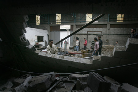 Palestinians check the site damaged by Israeli air strike in Gaza City, November 24, 2009. The Israeli army said it carried out three air strikes in the Gaza Strip, targeting the facility for manufacturing weapons and weapons-smuggling tunnels in response to rocket attacks on southern Israel from the Gaza Strip on the previous day. 