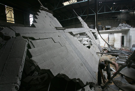 A Palestinian checks the site damaged by Israeli air strike in Gaza City, November 24, 2009. The Israeli army said it carried out three air strikes in the Gaza Strip, targeting the facility for manufacturing weapons and weapons-smuggling tunnels in response to rocket attacks on southern Israel from the Gaza Strip on the previous day. 