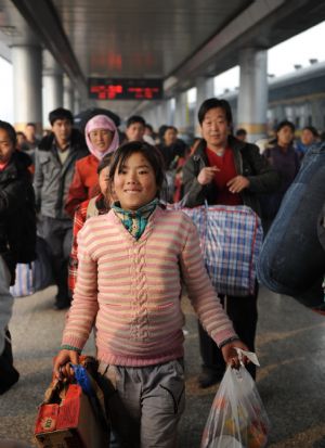 Farmers who have served as cotton pickers in neighboring Xinjiang Uygur Autonomous Region arrive in the railway station in Lanzhou, capital of northwest China&apos;s Gansu Province, on November 25, 2009.