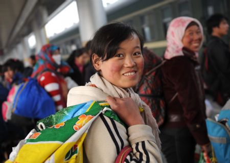 Farmers who have served as cotton pickers in neighboring Xinjiang Uygur Autonomous Region arrive in the railway station in Lanzhou, capital of northwest China&apos;s Gansu Province, on November 25, 2009.