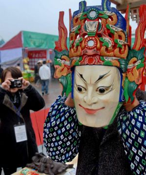 A folk artist shows the wooden Dixi Opera mask at the tourist products fair held in Guiyang, capital of southwest China&apos;s Guizhou Province, November 27, 2009. 
