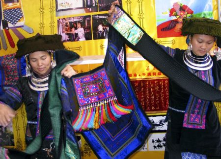 Girls of Miao ethnic group shows handmade embroideries at the tourist products fair held in Guiyang, capital of southwest China&apos;s Guizhou Province, November 27, 2009. 