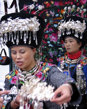 Women of Miao ethnic group show the handmade silver decorations at the tourist products fair held in Guiyang, capital of southwest China&apos;s Guizhou Province, November 27, 2009.