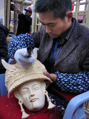 A folk artist carves a wooden handicraft at the tourist products fair held in Guiyang, capital of southwest China&apos;s Guizhou Province, November 27, 2009. 