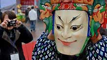 A folk artist shows the wooden Dixi Opera mask at the tourist products fair held in Guiyang, capital of southwest China's Guizhou Province, November 27, 2009. The 2009 'Colorful Guizhou' tourist products fair kicked off on Friday. Dozens of handicraftsmen presented their stunts at the fair.