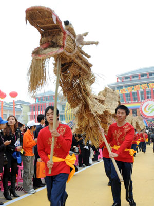 Young men of Mulam ethnic group dance with grass-knitted dragon during a traditional celebration in Luocheng Mulam Autonomous County of southwest China's Guangxi Zhuang Autonomous Region, November 28, 2009. Ethnic Mulam people celebrated the traditional festival of harvest and wishes on Saturday. 