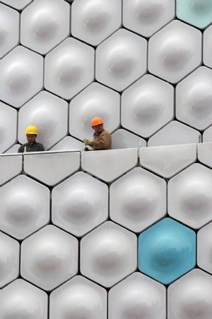 Workers proceed on the building site of Information and Communications pavilion of the 2010 Shanghai World Expo in Shanghai, east China, November 29, 2009. Most of the pavilions are taking on a dashing look with the coming of the 2010 Shanghai World Expo, which will fall in May of next year.