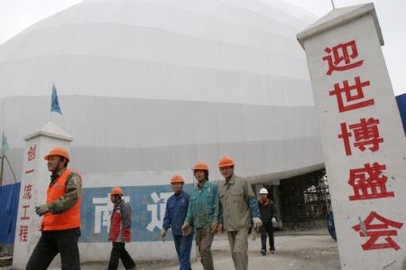 Workers walk out of the building site of China Aviation Pavilion of the 2010 Shanghai World Expo in Shanghai, east China, November 29, 2009. Most of the pavilions are taking on a dashing look with the coming of the 2010 Shanghai World Expo, which will fall in May of next year.