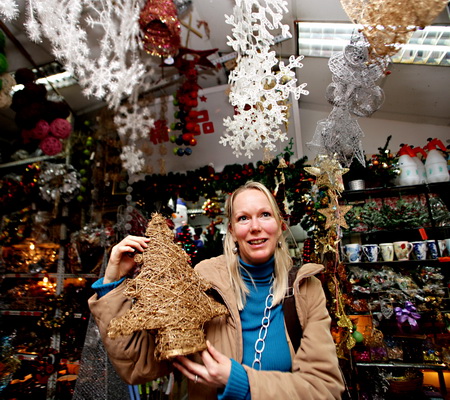 German tourist Marian Klug-Li picks Christmas decorations at the Beijing Liangma Flora Market Tuesday.