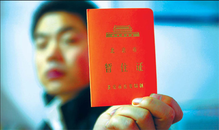 A man shows his temporary residence permit at a police station in Chaoyang District Wednesday.