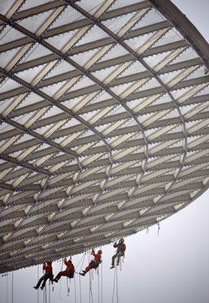 Workers install LED lights on the horn-shakped 'Sunny Valley' building of Expo Axis in Shanghai, east China, December 4, 2009. A great amount of energy saving equipments were employed in the construction of 2010 Shanghai World Expo.