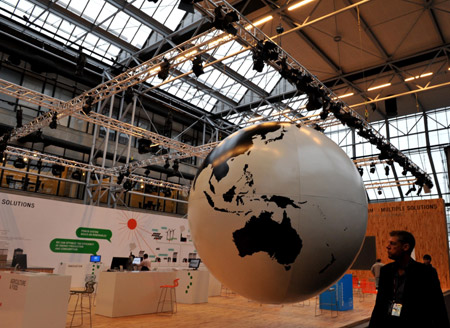 A man walks past a earth ball prior to the 15th United Nations Climate Change Conference (COP15) at Bella Center in Copenhagen, capital of Demark, December 6, 2009. The conference will be held from December 7 to 18.