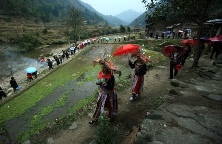 Relatives walk in queue on their way to the wedding ceremony, in Tonglian Township of Rongshui Miao Autonomous County, southwest China's Guangxi Zhuang Autonomous Region, December 6, 2009.