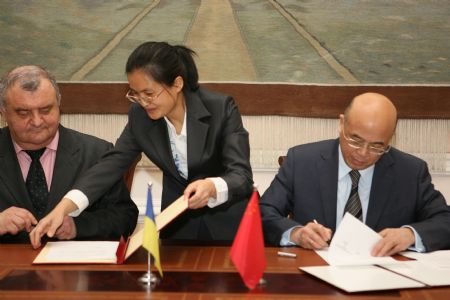 Chinese ambassador to Ukraine Zhou Li (R) and Ukraine's Deputy Minister of Health Igor Yakovenko (L) sign documents in Kiev, capital of Ukraine, December 7, 2009. The Chinese embassy in Ukraine signed a document with the Ukraine government here on Monday to allocate free aid worth of a total of 3.5 million yuan (about 500,000 USD) to help Ukraine combat the A/H1N1 flu epidemic.