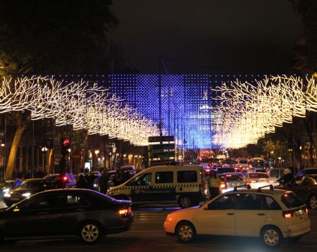 Vehicles drive on the Alcala Street decorated with lampions in Madrid, capital of Spain, December 7, 2009. With the Christmas drawing near, authorities of Madrid decorated the city with light bulbs to enhance the festive atmosphere.