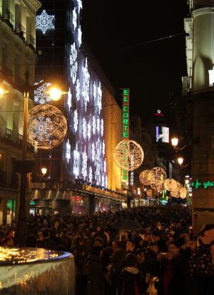 People walk on a commercial street decorated with lampions in Madrid, capital of Spain, December 7, 2009. With the Christmas drawing near, authorities of Madrid decorated the city with light bulbs to enhance the festive atmosphere.