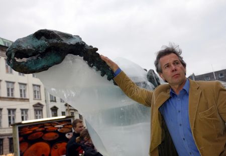 British explorer Pen Hadow touches an ice sculpture of a polar bear as it melts to reveal a bronze skeleton in Copenhagen December 8, 2009. The ice sculpture had been placed in downtown Copenhagen since December 5, 2009, to draw the attention of people about the rising temperature.