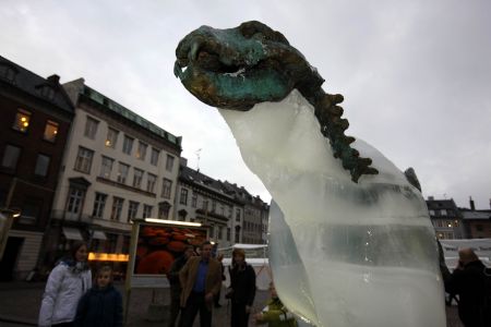 People watch an ice sculpture of a polar bear as it melts to reveal a bronze skeleton in Copenhagen December 8, 2009.