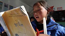 A pupil reads a book during a Tibetan-language class at the Complete Primary School of Bomdoi Township in Dagze County, southwest China's Tibet Autonomous Region, December 9, 2009.