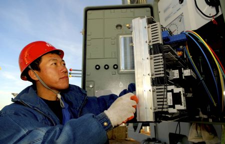 An electrician conducts on spot technical inspection and debugging to the apparatus of the 330 kilovoltage booster substation, at the Jiuquan Dongfeng Electricity Generation Field, in Guazhou County of Jiuquan City, northwest China's Gansu Province, December 8, 2009.