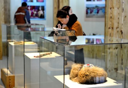 Visitors view exhibits at the newly opened Oroqen folk museum in the Nanmu Oroqen Ethnic Group Village, in Zhalantun City, north China's Inner Mongolia Autonomous Region, December 9, 2009. 