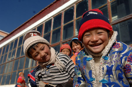 Pupils play in front of a classroom which uses solar energy for its heating devices in a village in Tibetan Autonomous Prefecture of Huangnan in northwest China&apos;s Qinghai Province, December 2, 2009.
