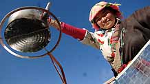 A villager uses solar energy to cook in a village in Tibetan Autonomous Prefecture of Huangnan in northwest China's Qinghai Province, December 3, 2009.