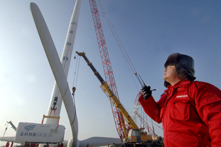 A worker instructs the installation of a huge wind turbine in Dabancheng of northwest China's Xinjiang Uygur Autonomous Region December 10, 2009.