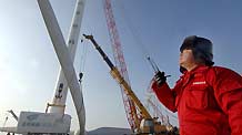A worker instructs the installation of a huge wind turbine in Dabancheng of northwest China's Xinjiang Uygur Autonomous Region December 10, 2009.