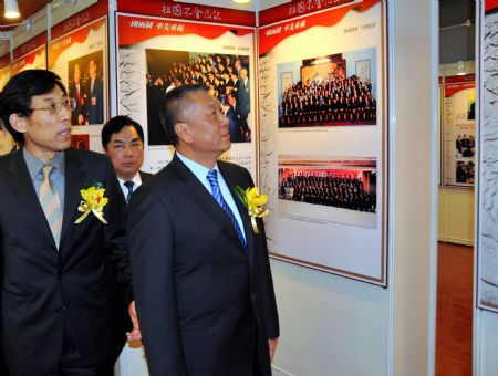 Edmund Ho Hau Wah (R), chief executive of Macao Special Administrative Region, visits a photo exhibition marking the 10th anniversary of Macao's return to China, in Macao, south China, December 10, 2009.