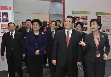 Li Changchun (2nd R, Front), member of the Standing Committee of the Political Bureau of the Communist Party of China Central Committee, visits a Confucius Institutes exhibition co-hosted by the Confucius Institutes headquarters and the State Language Commission of China, in Beijing, capital of China, December 11, 2009.