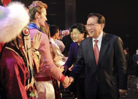 Li Changchun (R, Front), a Standing Committee member of the Political Bureau of the Communist Party of China Central Committee, shakes hands with students after their performance in Beijing, capital of China, December 11, 2009. Li watched here on Friday a performing art show presented by students of the Confucius Institutes from 22 countries and visited a Confucius Institutes exhibition.