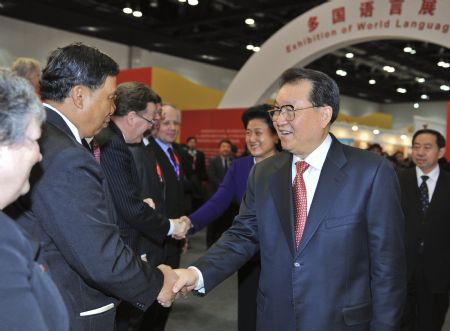 Li Changchun (R, Front), a Standing Committee member of the Political Bureau of the Communist Party of China Central Committee, shakes hands with the university heads from 87 countries who are here to attend the fourth conference of Confucius Institutes, in Beijing, capital of China, December 11, 2009. Li watched here on Friday a performing art show presented by students of the Confucius Institutes from 22 countries and visited a Confucius Institutes exhibition. 