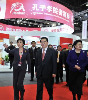 Li Changchun (C, Front), member of the Standing Committee of the Political Bureau of the Communist Party of China Central Committee, visits a Confucius Institutes exhibition co-hosted by the Confucius Institutes headquarters and the State Language Commission of China, in Beijing, capital of China, December 11, 2009.