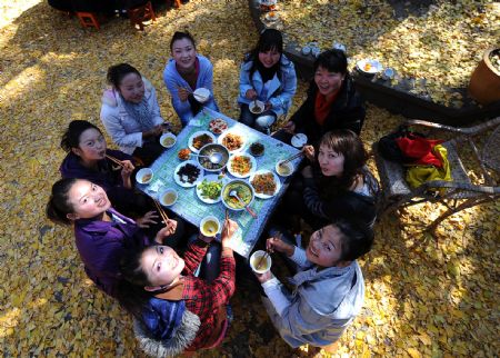 Tourists have lunch under ginkgo trees in Gudong Township of Tengchong County, southwest China&apos;s Yunnan Province, December 8, 2009.