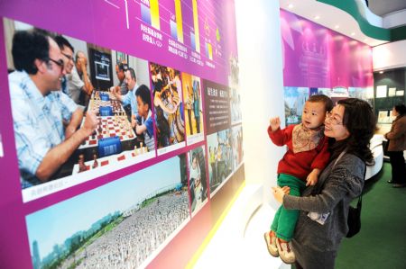 A woman holding her baby visits an exhibition of the achievements of the Macao Special Administrative Region (SAR) over the past decade, at the Capital Museum in Beijing, December 12, 2009.