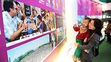 A woman holding her baby visits an exhibition of the achievements of the Macao Special Administrative Region (SAR) over the past decade, at the Capital Museum in Beijing, December 12, 2009.