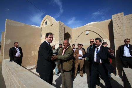 John Ging (1st L front), director of the UN Relief and Works Agency (UNRWA), talks with Majed al-Athamna (2nd L front) as he handed a new house to Majed's family in northeast Gaza Strip, December 12, 2009.