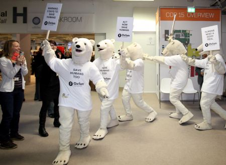 Environmentalists wearing polar bear costumes hold placards at the Bella center of Copenhagen, capital of Denmark, December 14, 2009, during the UN Climate Change Conference.