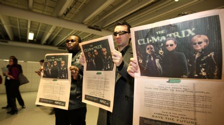 Environmentalists hold press adverts depicting (L to R) US President Barack Obama, Japanese Prime Minister Yukio Hatoyama and German Chancellor Angela Merkel as characters from science fiction-adventure film the Matrix and call on the three heads of state to use their power to achieve a planet-saving climate deal at the Bella center of Copenhagen, capital of Denmark, December 14, 2009, during the UN Climate Change Conference.