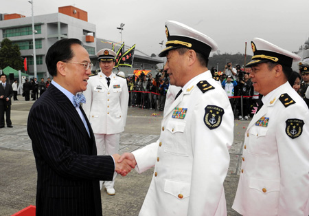 Donald Tsang Yam-kuen (L, front), chief executive of the Hong Kong Special Administrative Region, shakes hands with Wang Zhiguo, commander of the Chinese naval 3rd escort fleet, in Hong Kong, south China, on December 14, 2009. 