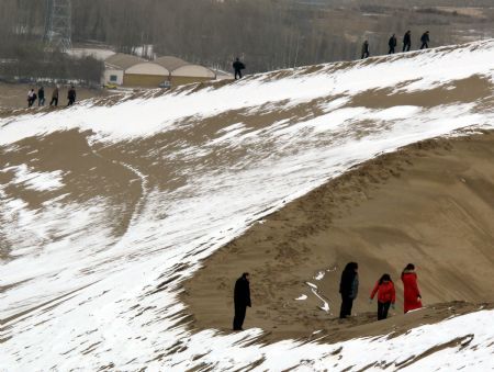 Tourists climb the snow covered Mingshashan in Dunhuang, northwest China&apos;s Gansu Province December 14, 2009. 