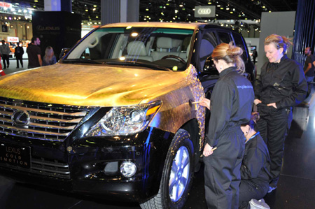 Artisans decorate a new Lexus LX 570 SUV with pieces of gold foil during the media day of the 10th Dubai Motor Show in Dubai, the United Arab Emirates, on December 15, 2009.