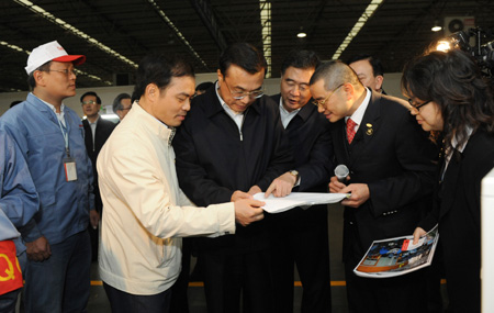 Chinese Vice Premier Li Keqiang (C) reads the pay slip of the workers of Galanz Group in Zhongshan City, south China's Guangdong Province, December 15, 2009. Li Keqiang made an inspection tour in Guangdong from December 14 to December 16.