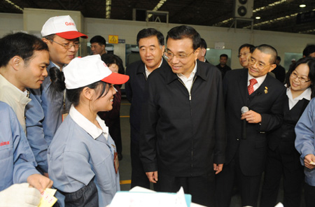 Chinese Vice Premier Li Keqiang (C) talks with workers of Galanz Group in Zhongshan City, south China's Guangdong Province, December 15, 2009. Li Keqiang made an inspection tour in Guangdong from December 14 to December 16. 