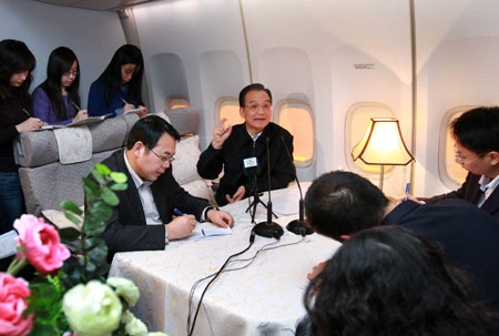 Chinese Premier Wen Jiabao (C) talkes with journalists on the chartered plane to Copenhagen, capital of Denmark , on December 16, 2009.