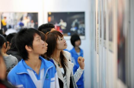 Visitors view the photos during a photo exhibition of the 2009 Universal Children's Day in Haikou, capital of south China's Hainan Province, December 17, 2009. Some 100 photos covering the 2009 Universal Children's Day are open to public during the 3-day-long exhibition.