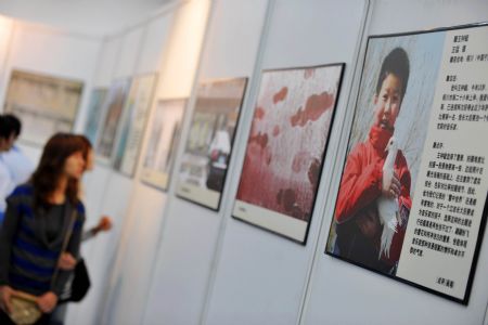 Visitors view the photos during a photo exhibition of the 2009 Universal Children's Day in Haikou, capital of south China's Hainan Province, December 17, 2009. 