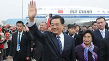 Chinese President Hu Jintao(L) waves upon his arrival at Macao International Airport in Macao Special Administrative Region (SAR) in south China December 19, 2009.